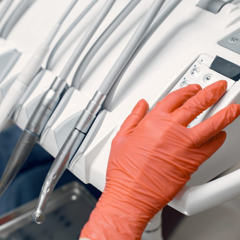 Dentist takes the instruments. Doctor in protective gloves.Medic uses the device